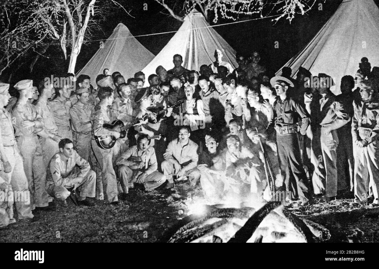 US actress Dorothy Lamour (middle) sings songs around a campfire with a group of American soldiers in Hawaii. Stock Photo
