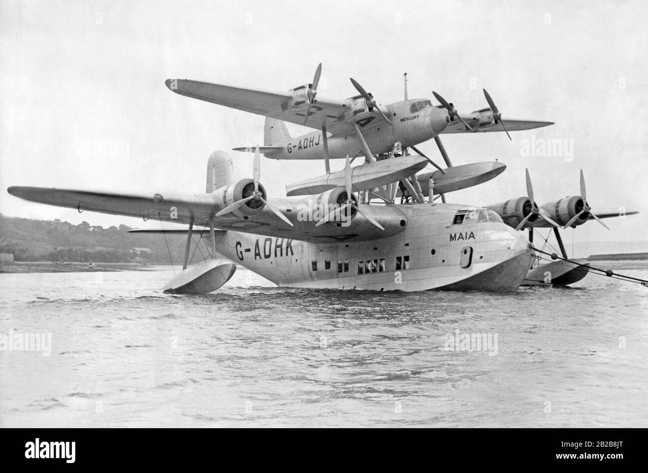 The Short Mayo Composite aircraft consists of a Short Empire flying boat (G-ADHK 'Maia') which carries a smaller Short Mercury seaplane (G-ADHJ). The 'Mercury' was carried by the 'Maia' up to cruising altitude, then the planes parted company and the 'Maia' returned to the airport of departure. Thus the 'Mercury' could cover longer distances. Stock Photo