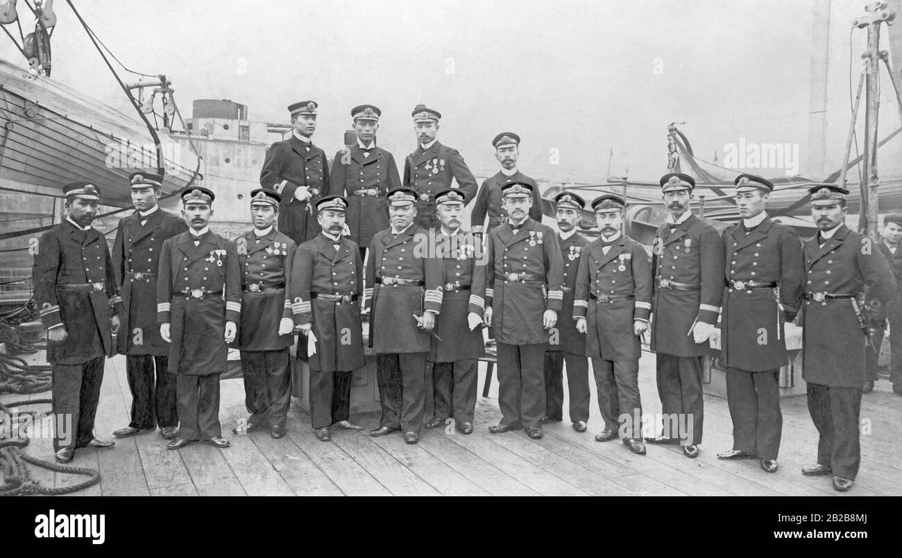 A group of Japanese naval officers posing for a group photo on deck of a warship. Stock Photo