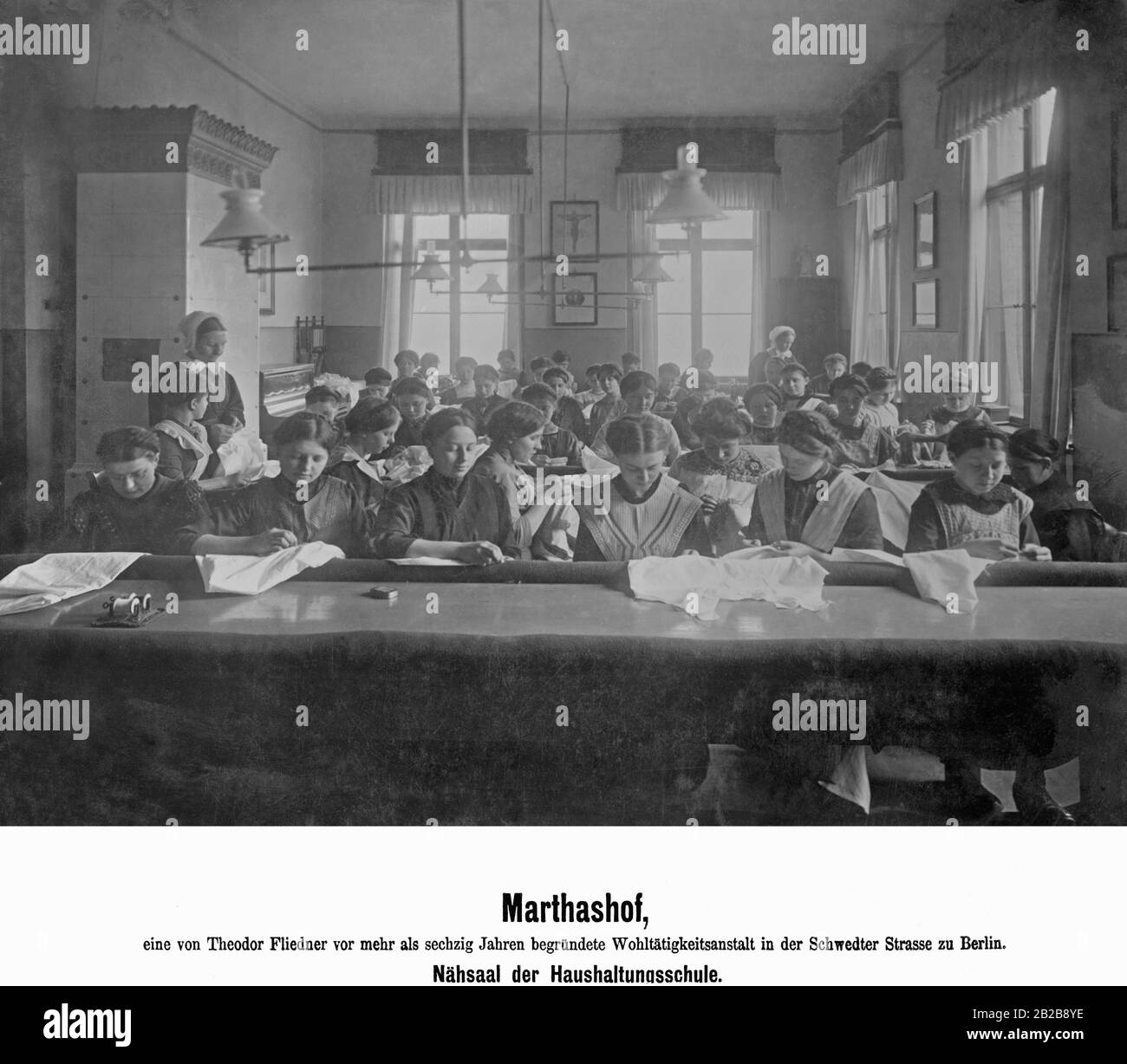 The photo shows the sewing room of the Marthashof Home Economics School in Schwedter Strasse in Berlin. This is a charitable institution founded by the protestant pastor Theodor Fliedner. Stock Photo