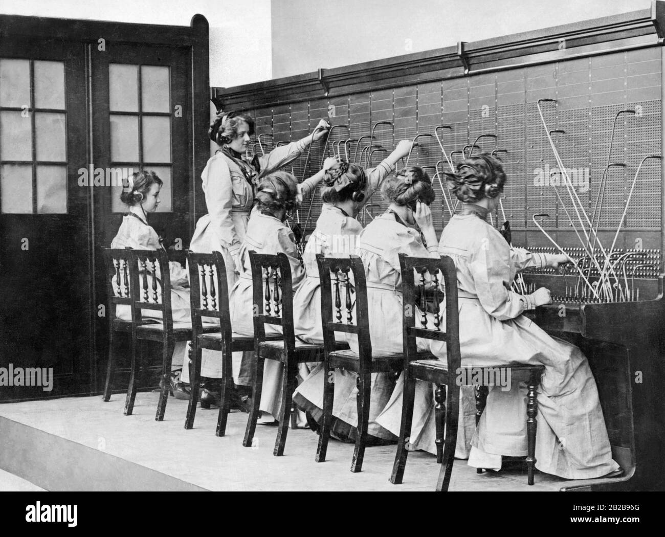 The connection of telephone lines were made by the 'switchboard operators', as shown in the photo. Stock Photo