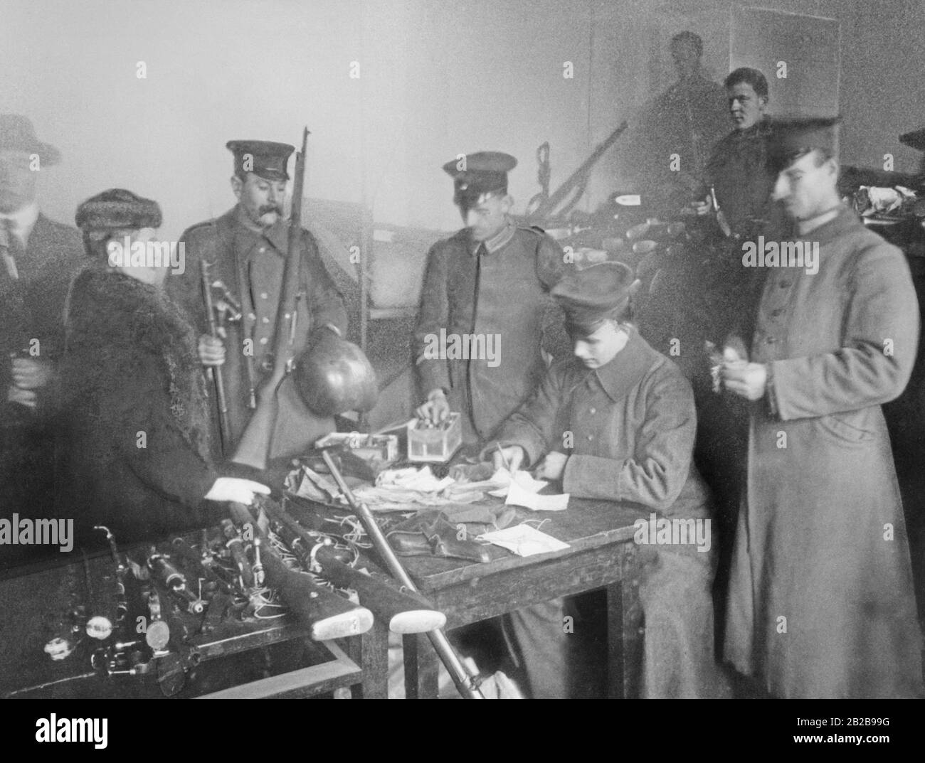 A snapshot from the weapons collection point of the Alexanderkaserne in Berlin in the winter of 1918/19, where, among others, some women are also responsible for ensuring that the men returning from the front deliver their weapons. Stock Photo