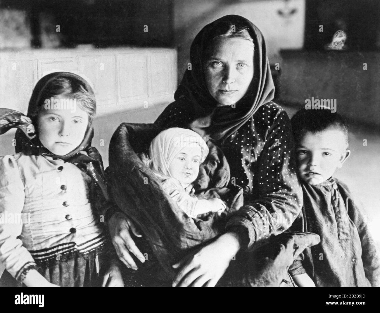 A mother from Eastern Europe with her three children at the port of Hamburg shortly before embarking for America. Stock Photo
