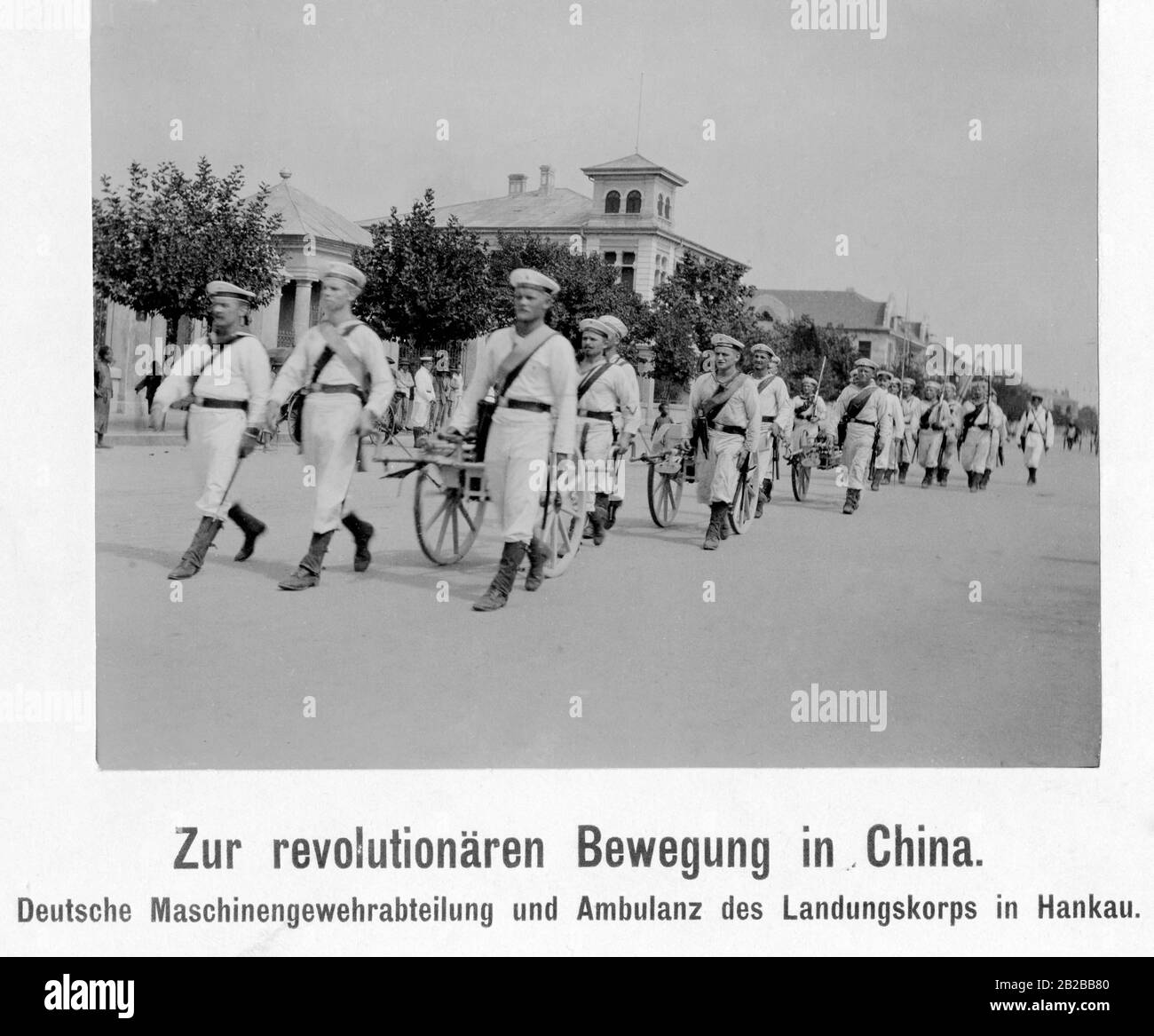 A German machine gun detachment and ambulance of the Landungskorps marches across a street in the German colony in Hankou in China, during the Chinese Revolution. Stock Photo