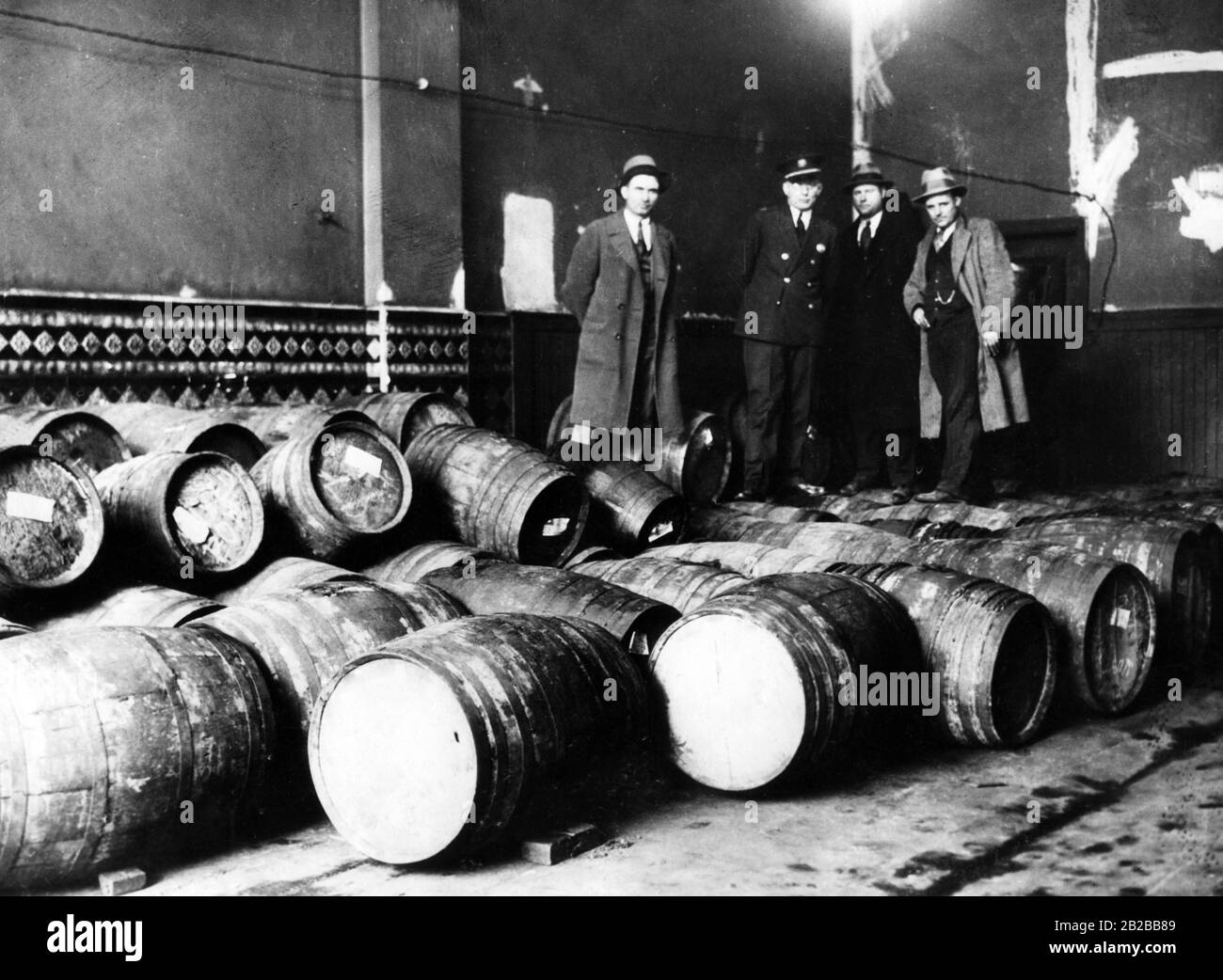 Prohibition: Policemen of the raiding squad (L.J. Broderick, Captain La Reau, Frank Butler and Robert Farron) and barrels with confiscated alcohol from Daniel Dever in Philadelphia. Stock Photo