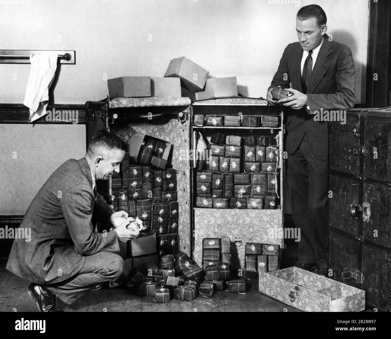 Prohibition: Policemen look at pure alcohol that was confiscated in a washing room (undated picture). Stock Photo