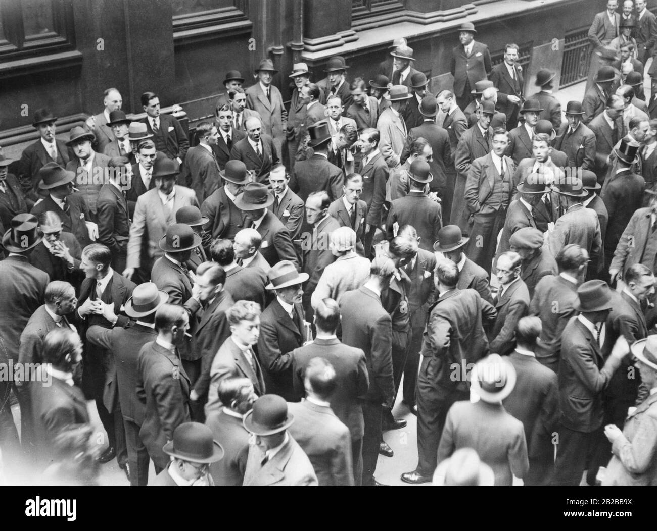 The Great Depression in Great Britain: People talking in front of the stock exchange about the Great Depression. Stock Photo