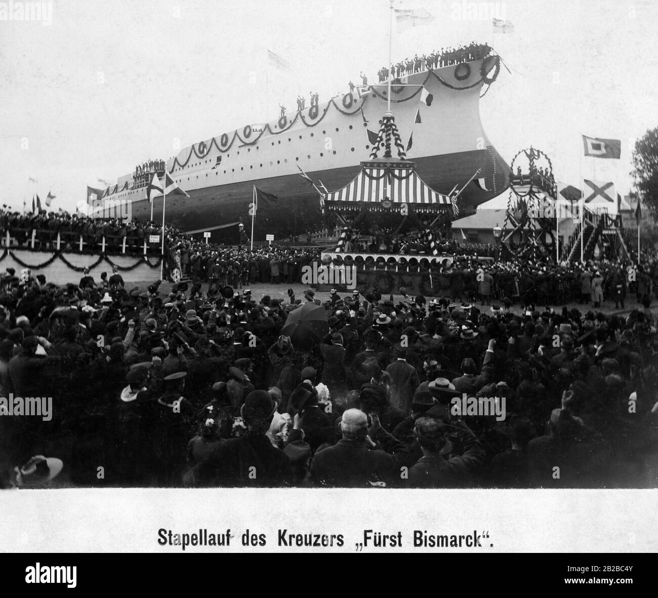 On the occasion of the launch of the cruiser SMS Fuerst Bismarck many guests gather at the imperial shipyard in Kiel. Marines are standing on the ship. The ship is an armoured cruiser. Stock Photo