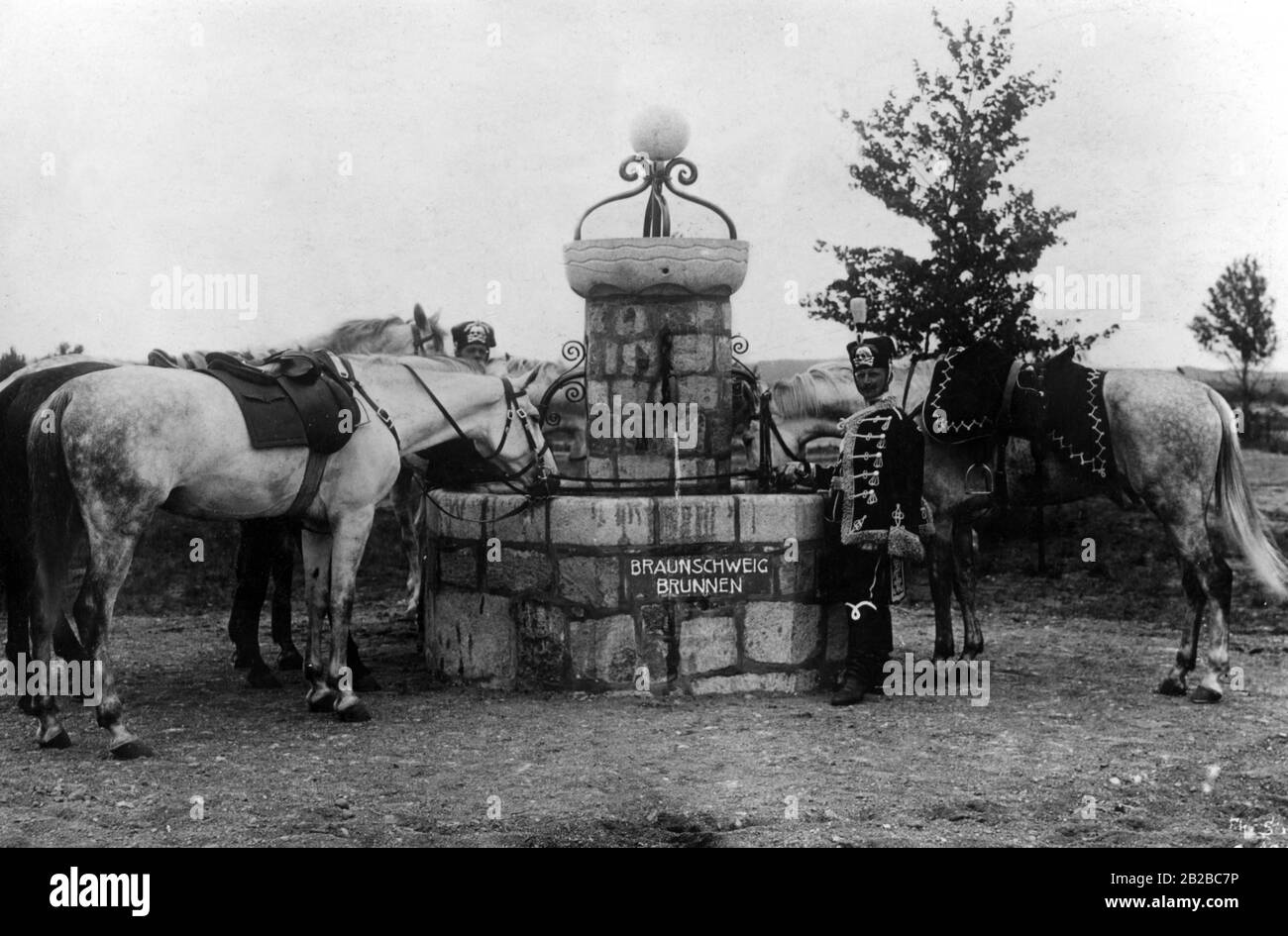 Two Death's Head Hussars ( Life Guard Hussars) with their horses at the Braunschweig fountain on the military training area. Stock Photo