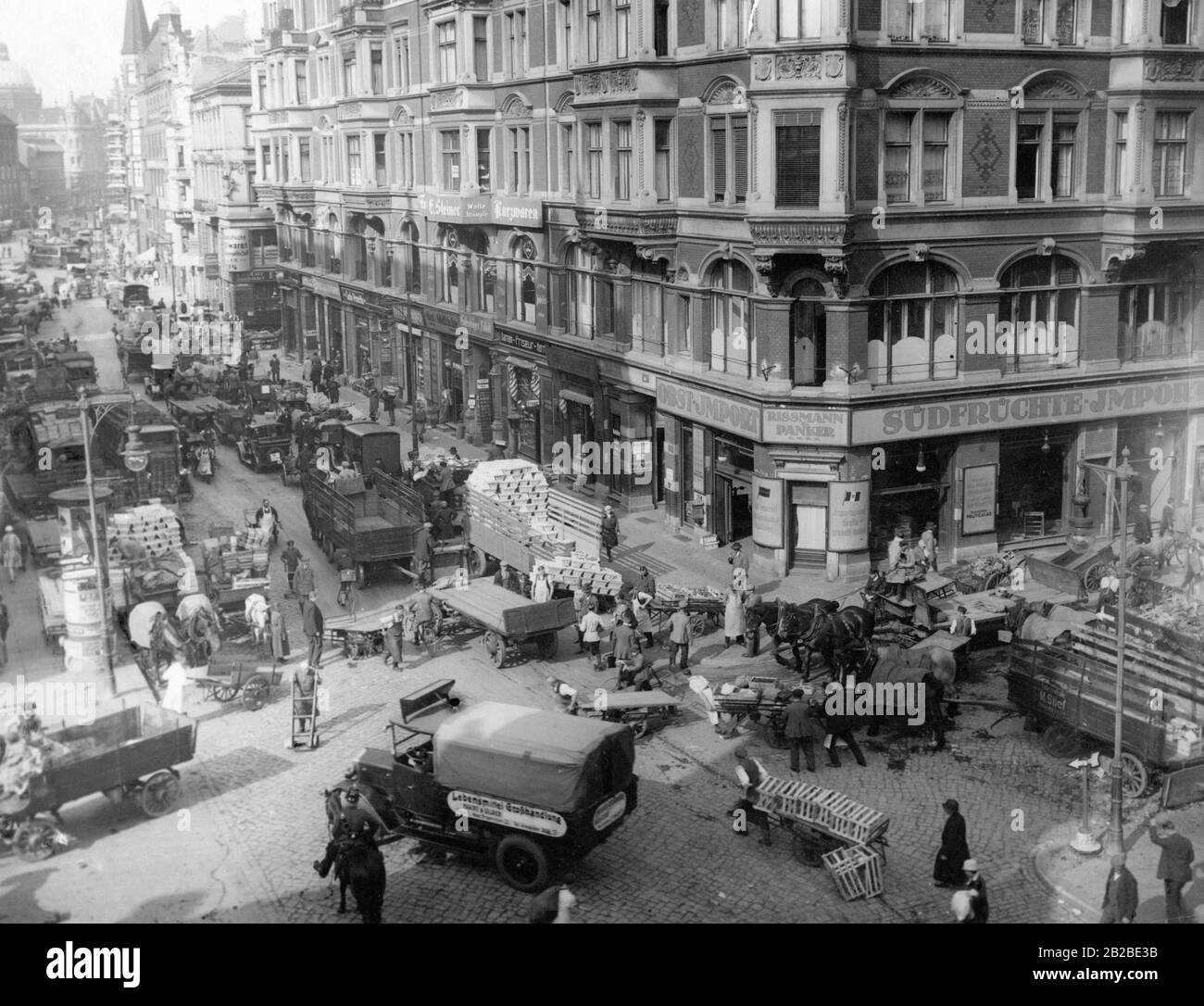 Market activity at the Berliner Markthalle on the corner of Kaiser-Wilhelm-Strasse and Neuer Friedrichstrasse. Top left, the dome of the City Palace. Stock Photo