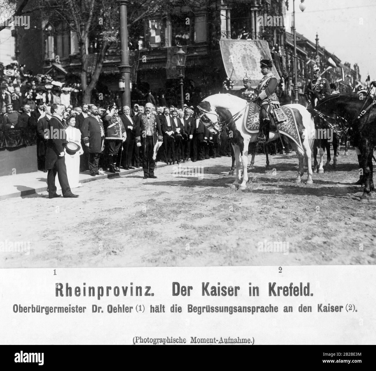 The Mayor of Krefeld, Adalbert Oehler, gives a welcome address to Kaiser Wilhelm II. Next to the Lord Mayor is his daughter Ilse Oehler.Wilhelm sits on a horse in the uniform of the 1. Leib-Husaren-Regiments Nr. 1. Right and left behind Wilhelm are two generals of the German Army, on the left the General Moritz von Bissing with (among others) the following orders: Black Eagle Order, Red Eagle Order, Iron Cross II Class (1870). The picture was taken at the corner of Rheinstrasse and Ostwall. Stock Photo