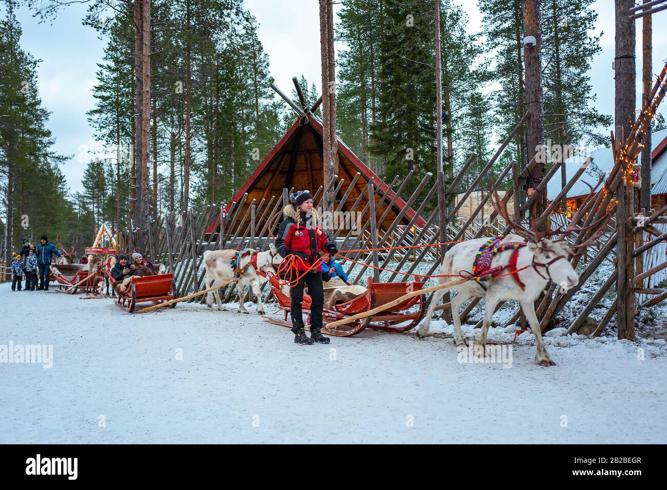 Rovaniemi, Finland, Tourists on reindeer-drawn sledges in the Santa Claus Village and Park Stock Photo