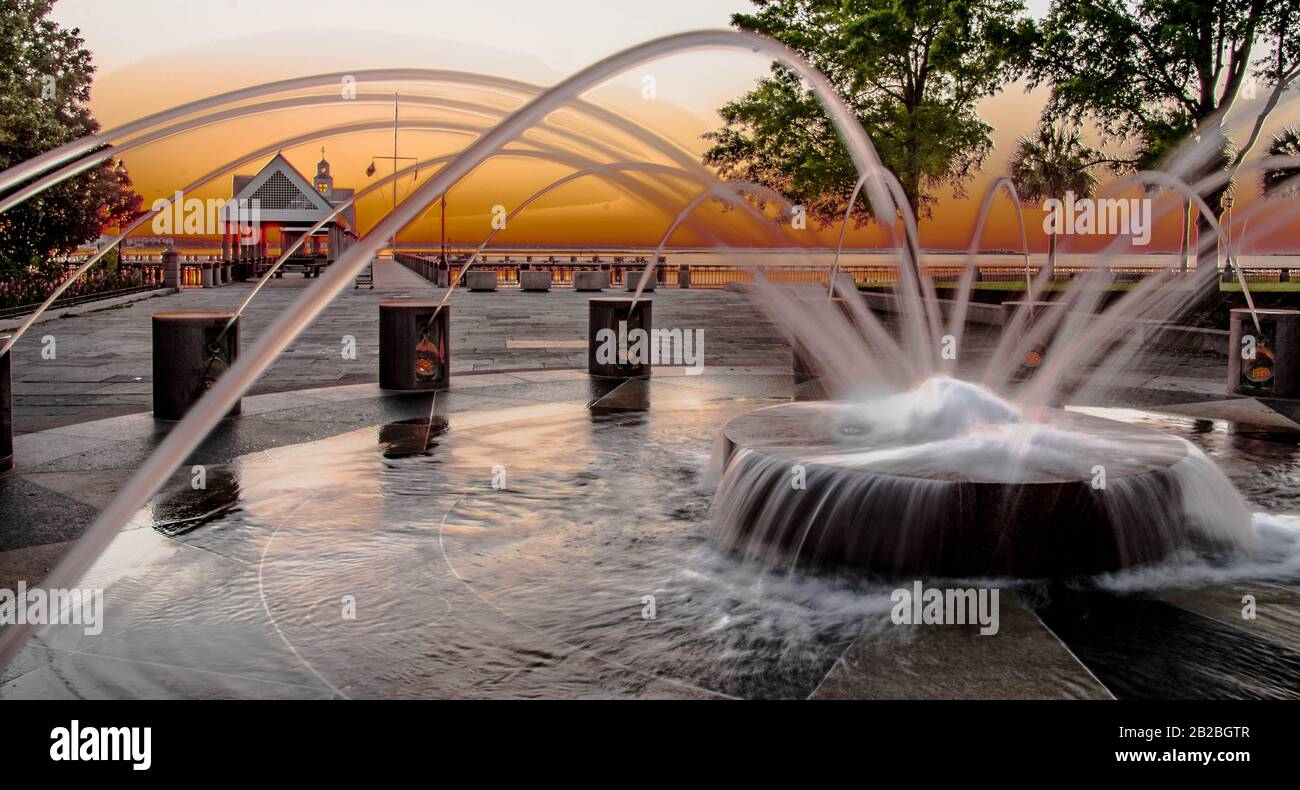 The sun rises at Waterfront Park in Charleston South Carolina where this fountain is a popular  feature of  the public  green space. Stock Photo
