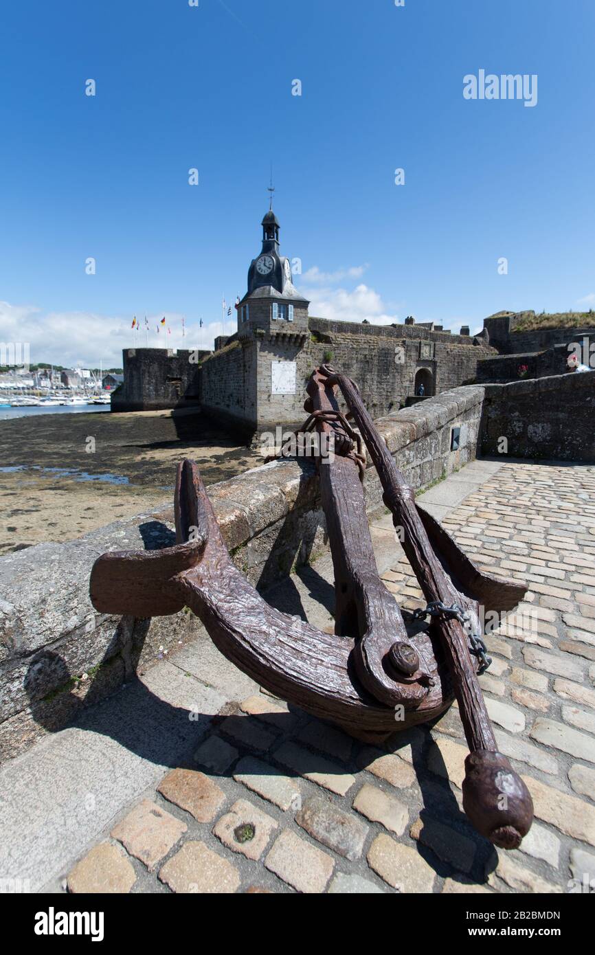 Town of Concarneau, France. Picturesque view of a rusted anchor on the bridge of Ville Close, with the medieval Ville Close in the background. Stock Photo