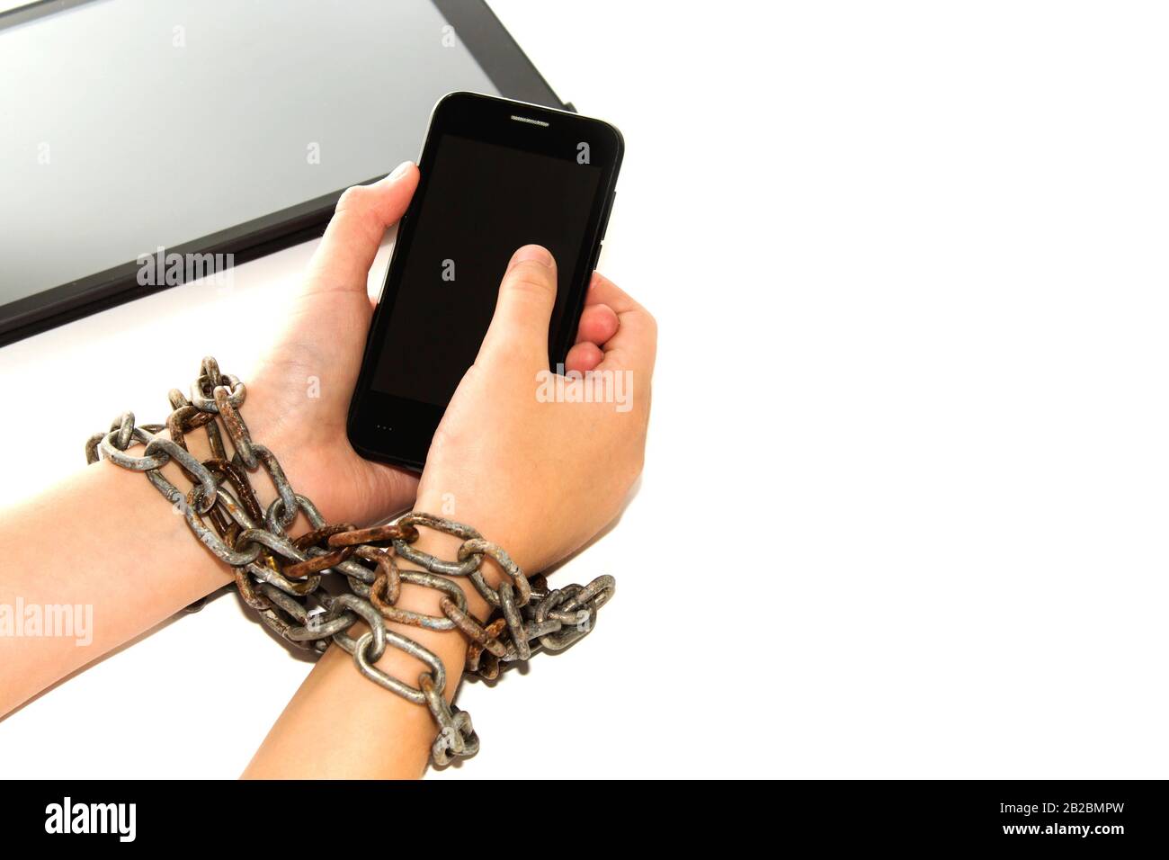 Iron chain ties together hands and smartphone - mobile phone addiction concept Stock Photo