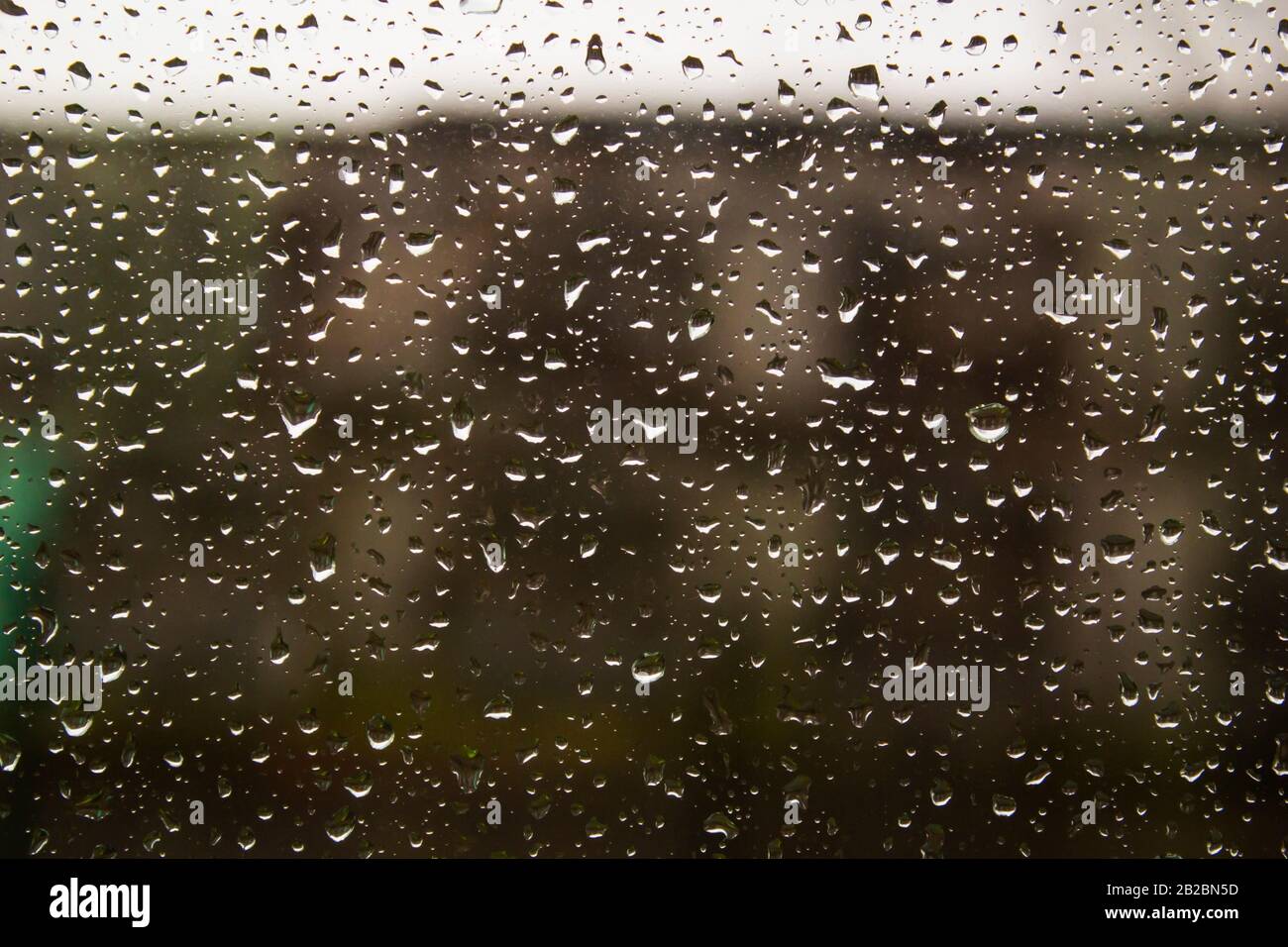 Traffic in rainy day with road view through car window with rain drops ...