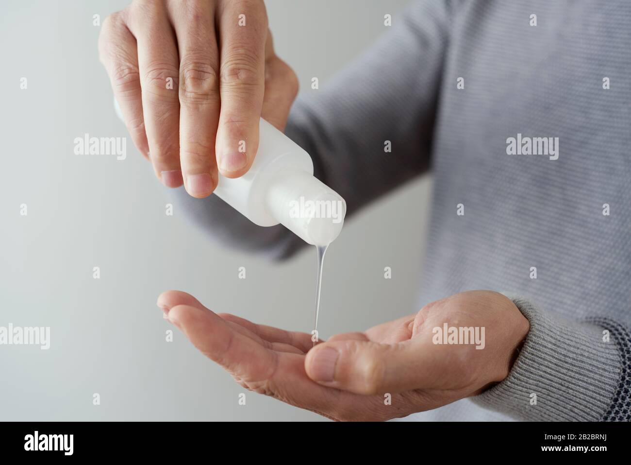closeup of a caucasian man disinfecting his hands with hand sanitizer from a bottle Stock Photo