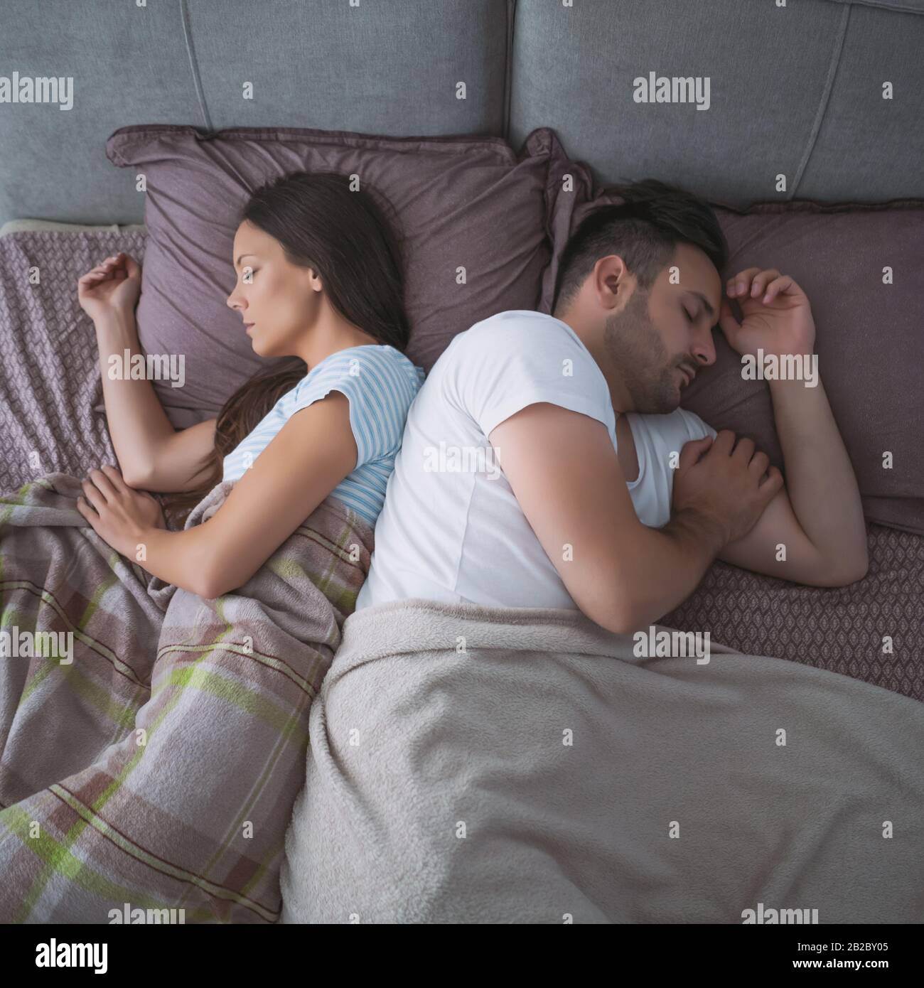 Young couple is sleeping in their bed. Stock Photo
