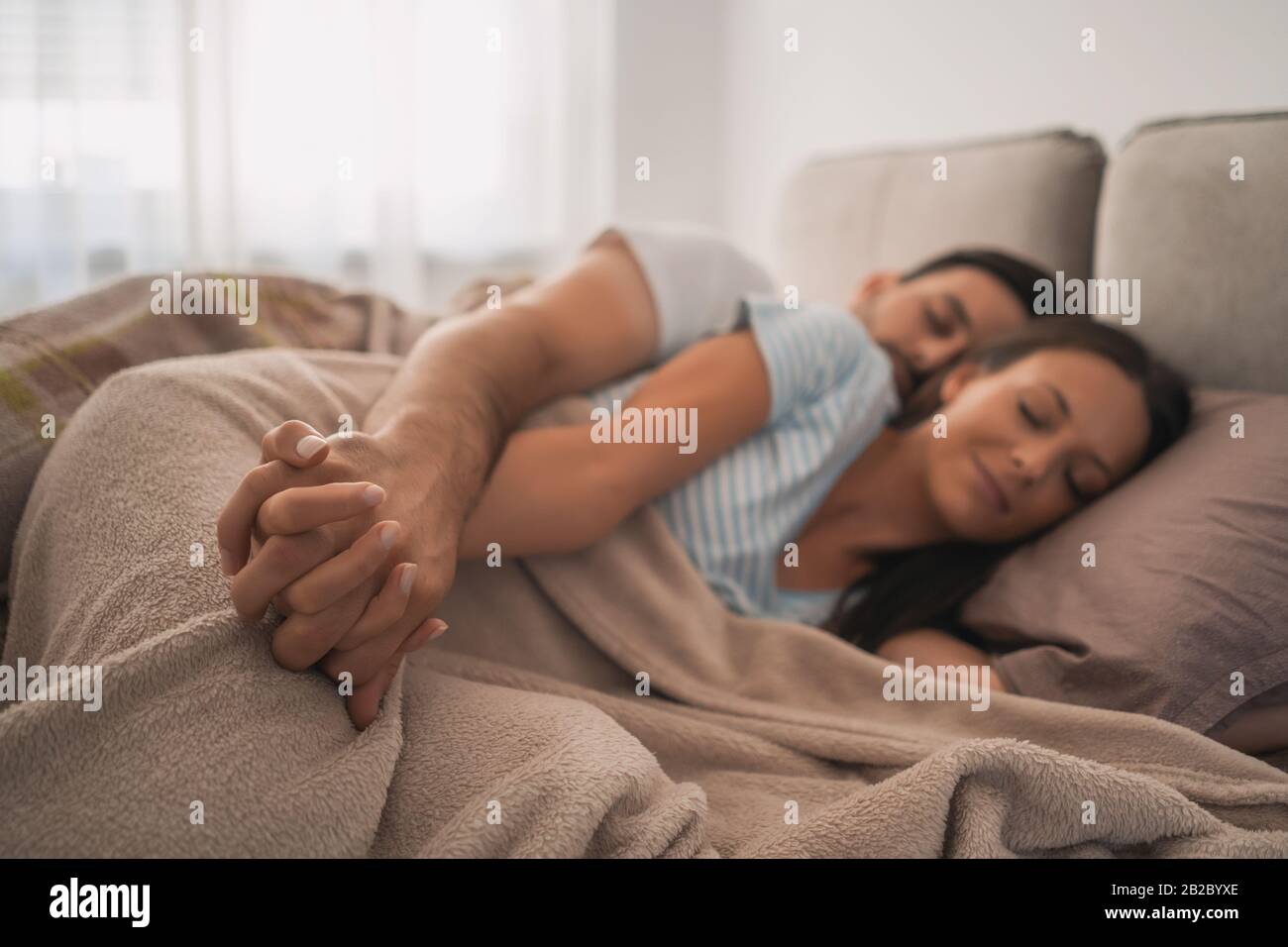 Young couple is sleeping in their bed. Stock Photo