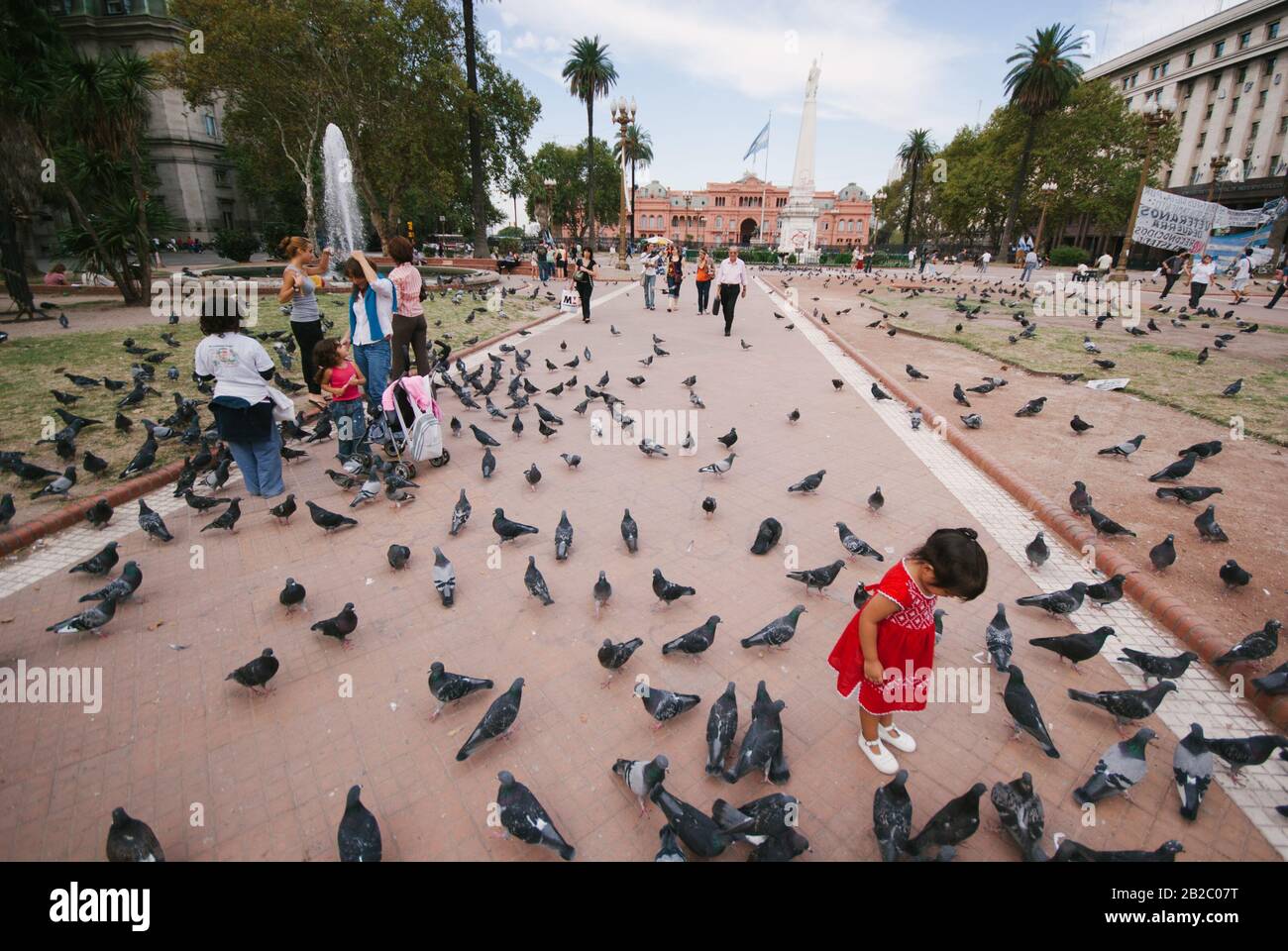 BUENOS AIRES,ARGENTINA-APRIL 7:  people walk betweeen a moltitutde of pigeons  in  the Plaza de Mayo in front  of the Casa Rosada  on the 7th april 20 Stock Photo