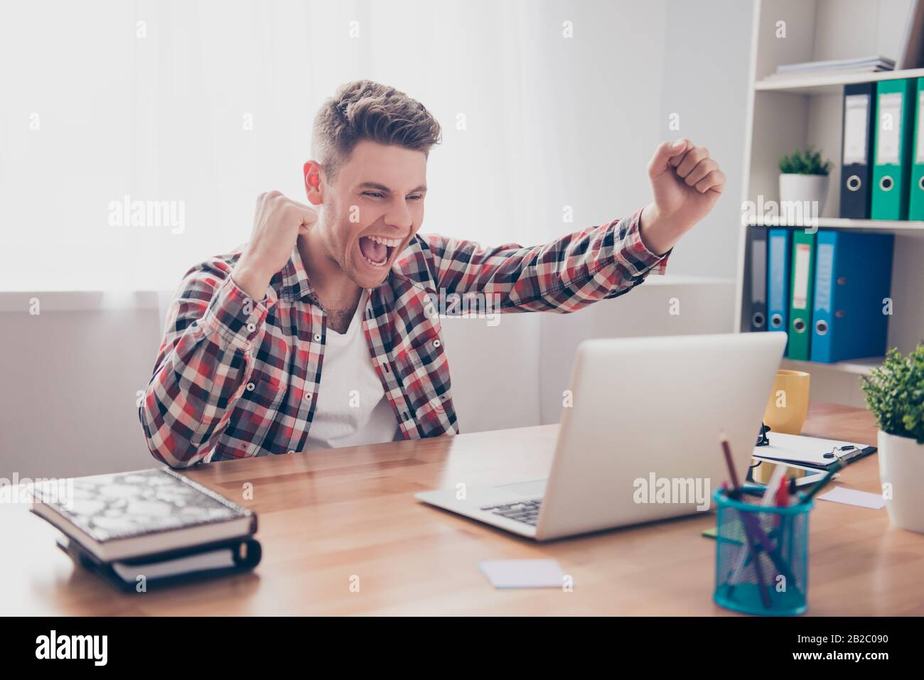 Happy man completed task and triumphing with raised hands Stock Photo ...