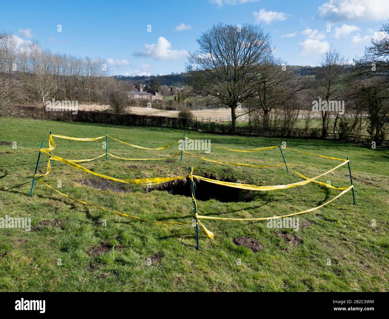 3M Sinkhole opens near Wirksworth, Derbyshire after heavy rain from Storm Jorge The sinkhole is around 3 meters wide & 6 meters deep, with water in the bottom appeared in Saturday 29th February 2020 in a field off Summer Lane on the outskirts of the Gem of the Peak, Wirksworth, Derbyshire. The sinkhole is thought to be part of old lead mining works which litter this Derbyshire countryside. It's believed that it opened up due to the heavy rain from the storms we have been having which in turn is washing the underground debris from old min workings making the areas above unstable & potentially Stock Photo