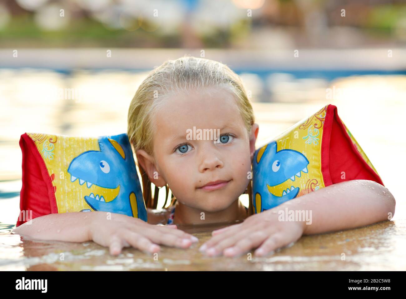 Girl in a life jacket swims in the pool Stock Photo Alamy