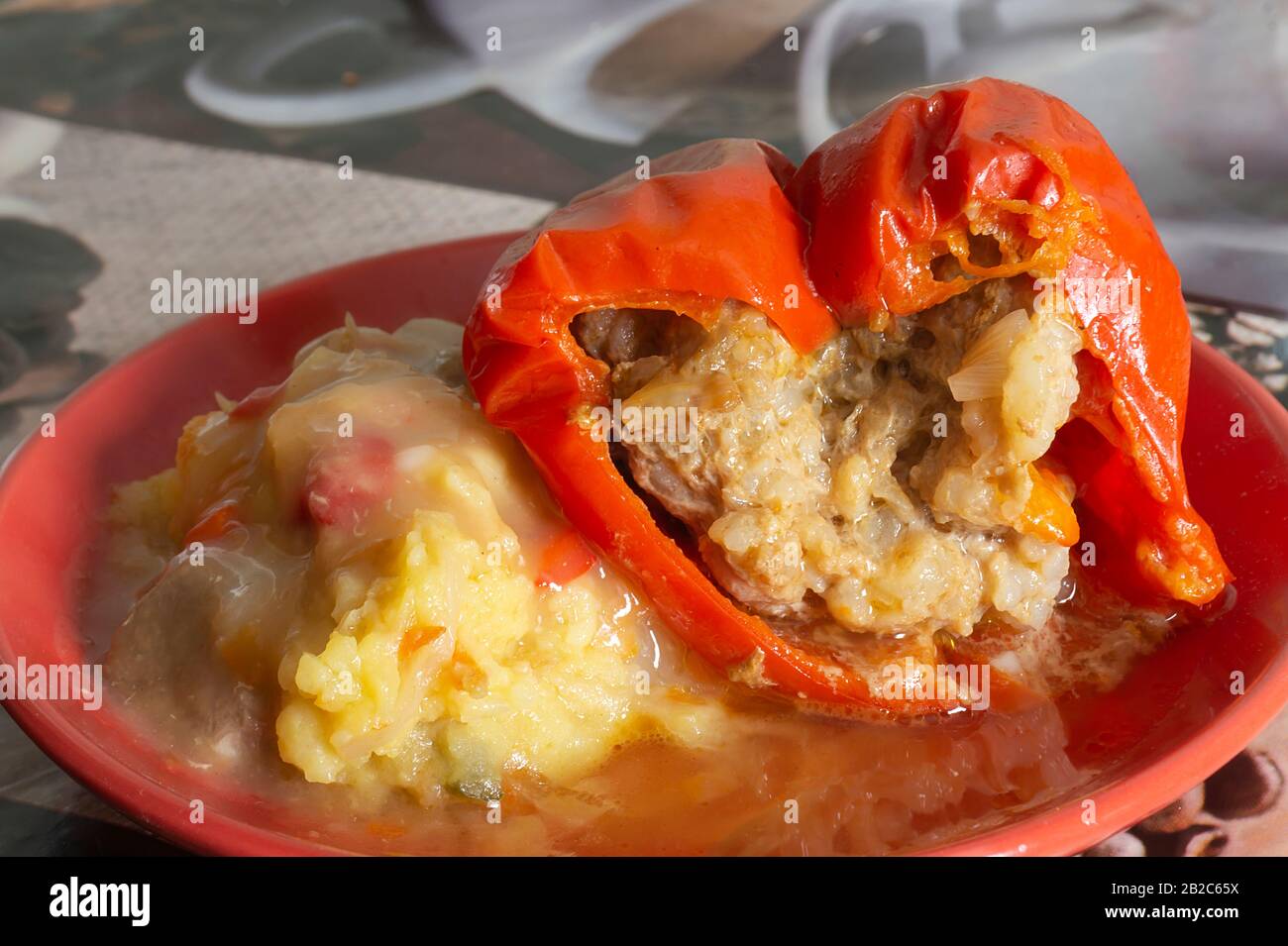 The Red pepper with stuffing and mashed potatoes in plate. The Hot dinner on table. Close-up of the products of the feeding Stock Photo
