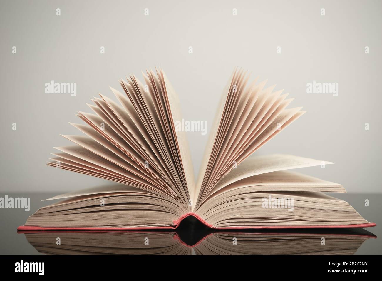 Beautiful open book on a gray and glass table background. Stock Photo
