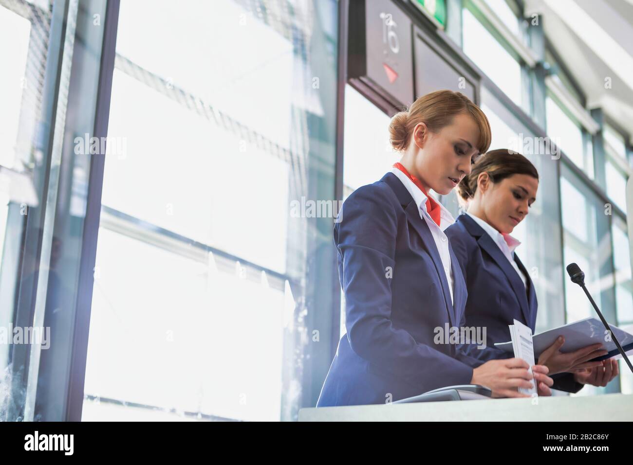 Portrait of young attractive passenger service agent opening the gate for boarding in airport Stock Photo