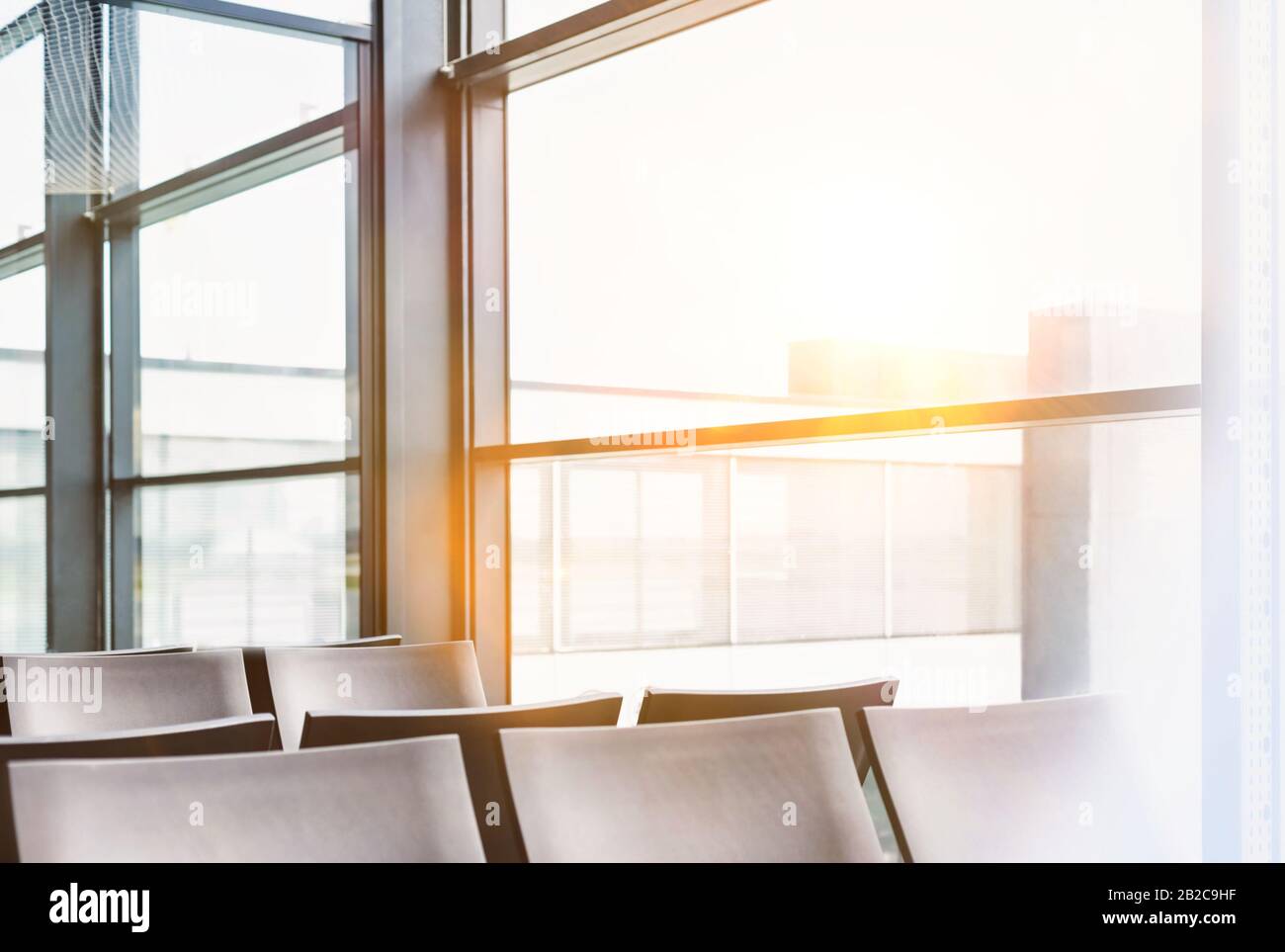 Photo of empty chairs on airport gate with lens flare Stock Photo