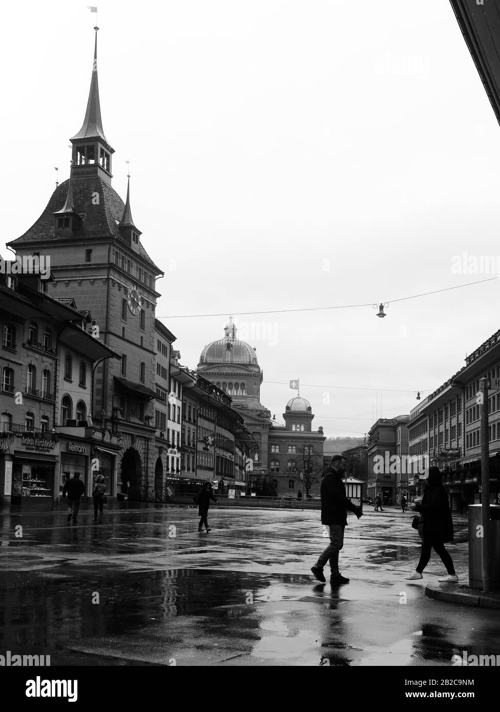 Bern, Switzerland. Käfigturm, a 17th-century Baroque tower with a clock and bell; Bundesplatz, and Bundeshaus, The Parliament Building in the BG. Stock Photo