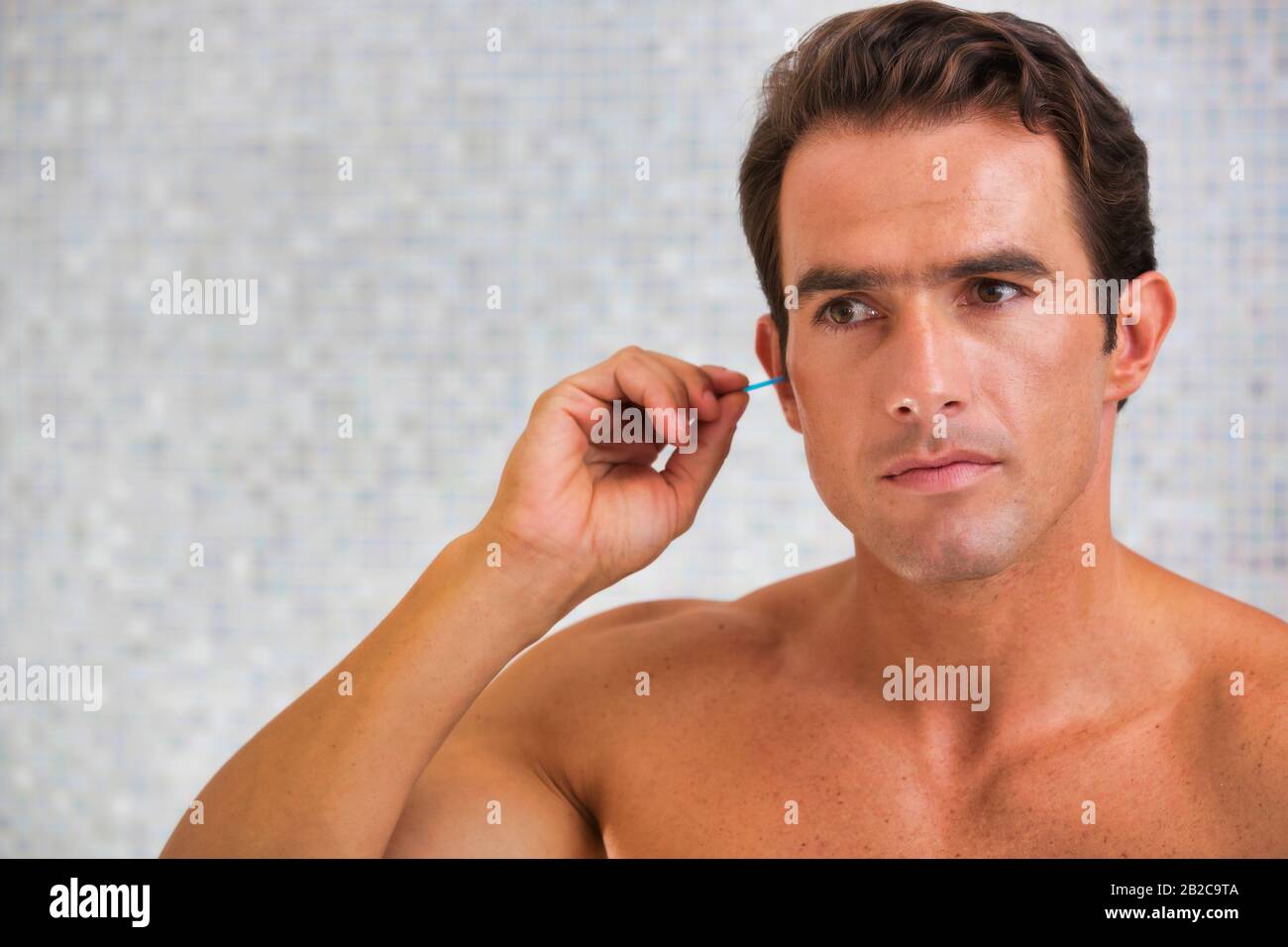 Man cleaning his ear with cotton bud Stock Photo Alamy