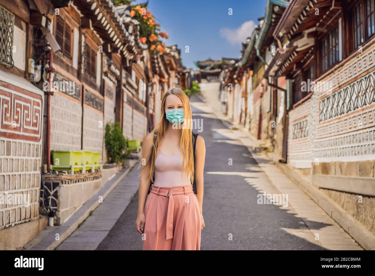 Young woman tourist in medical mask in Bukchon Hanok Village is one of ...