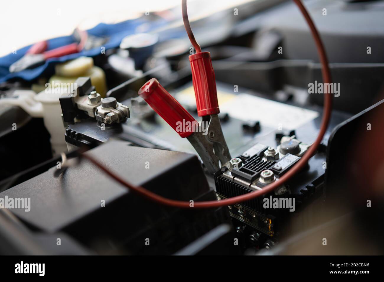 Close-up of battery car jumper on the red positive pole while battery service before change new one for feeding electrical to the car before replace w Stock Photo