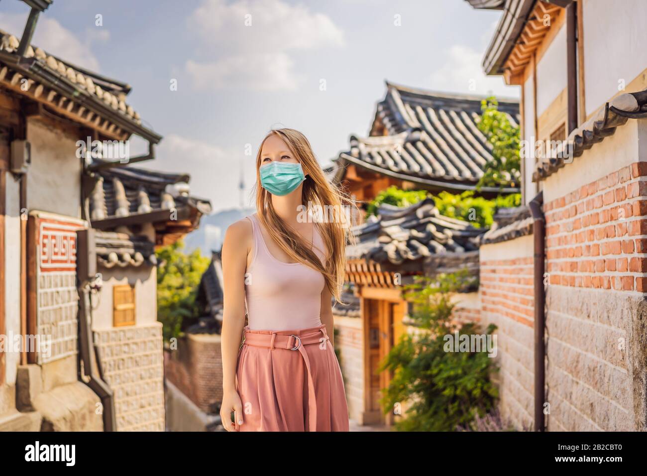 Young woman tourist in medical mask in Bukchon Hanok Village is one of ...