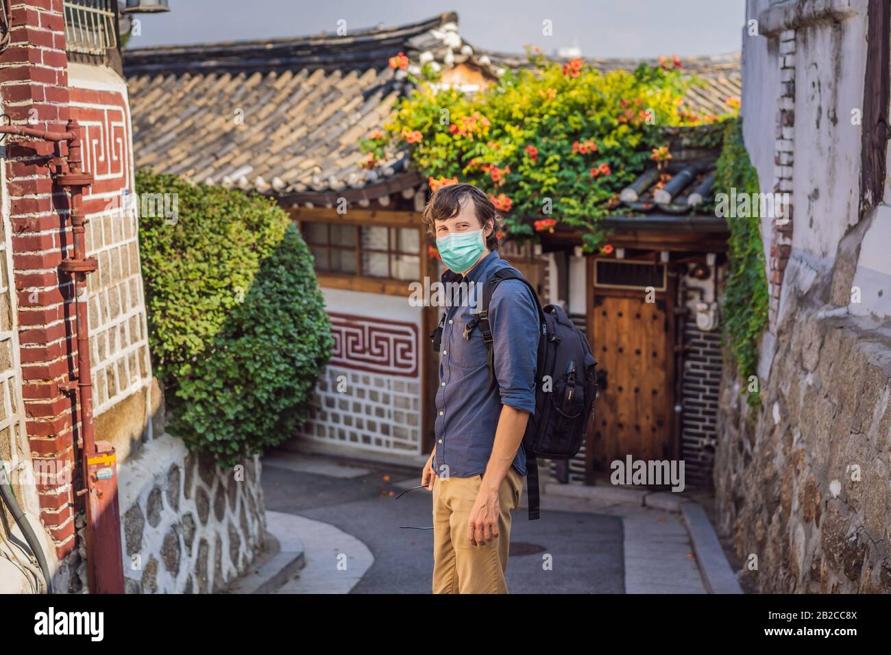 Young man tourist in medical mask in Bukchon Hanok Village is one of ...