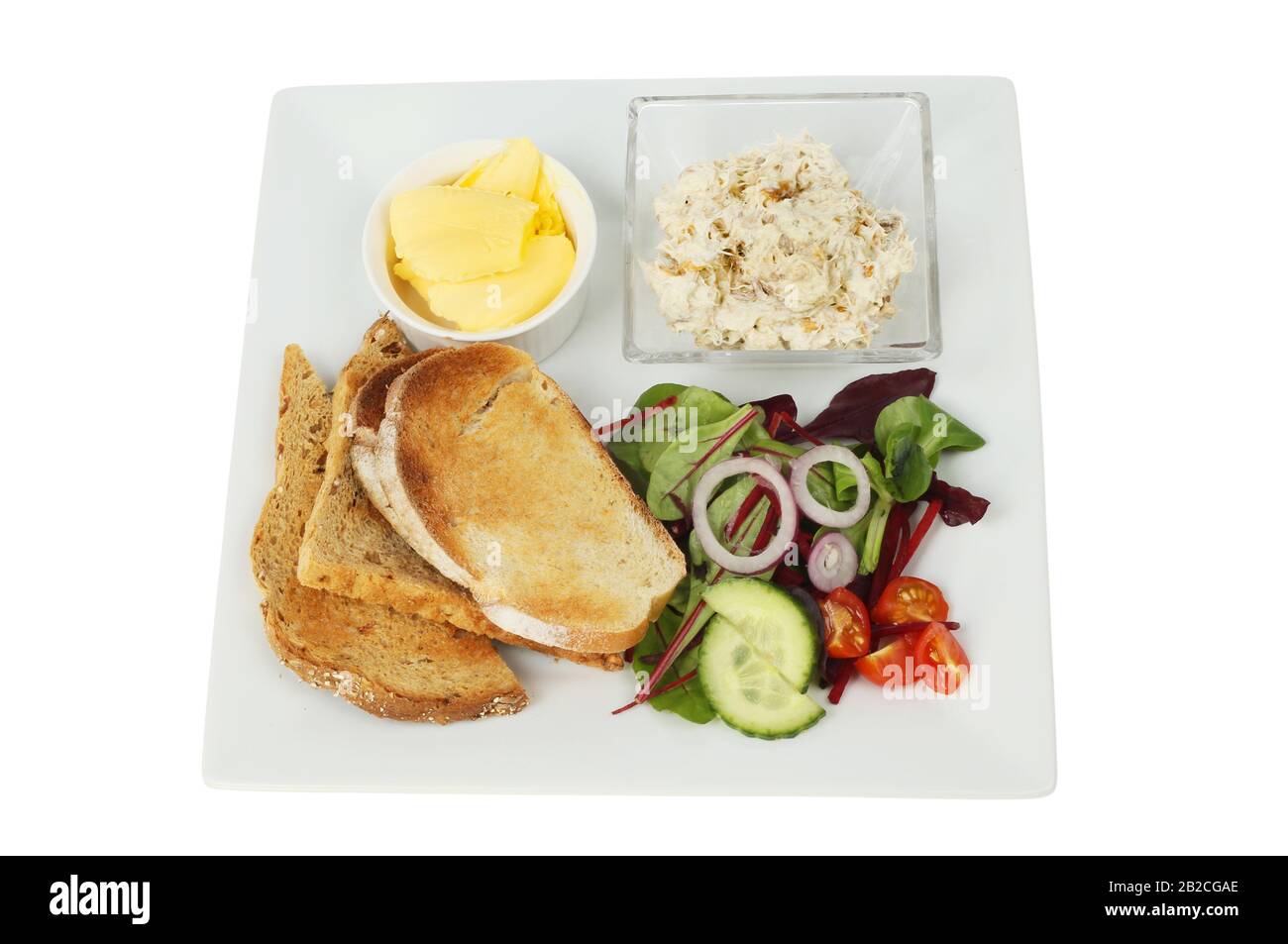 Smoked mackerel pate, toast, butter and toast on a plate isolated