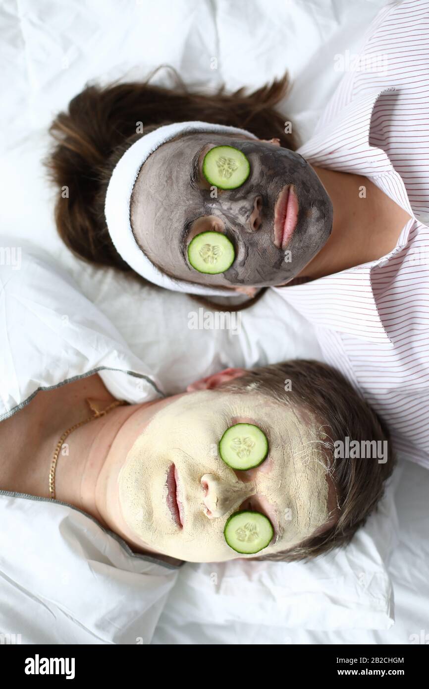 Man and woman put on face mask and cucumbers Stock Photo