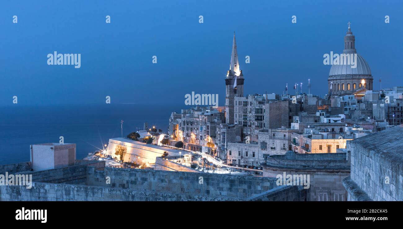 View of Old town roofs, fortress, Our Lady of Mount Carmel church and St. Paul's Anglican Pro-Cathedral at night, Valletta, Capital city of Malta Stock Photo