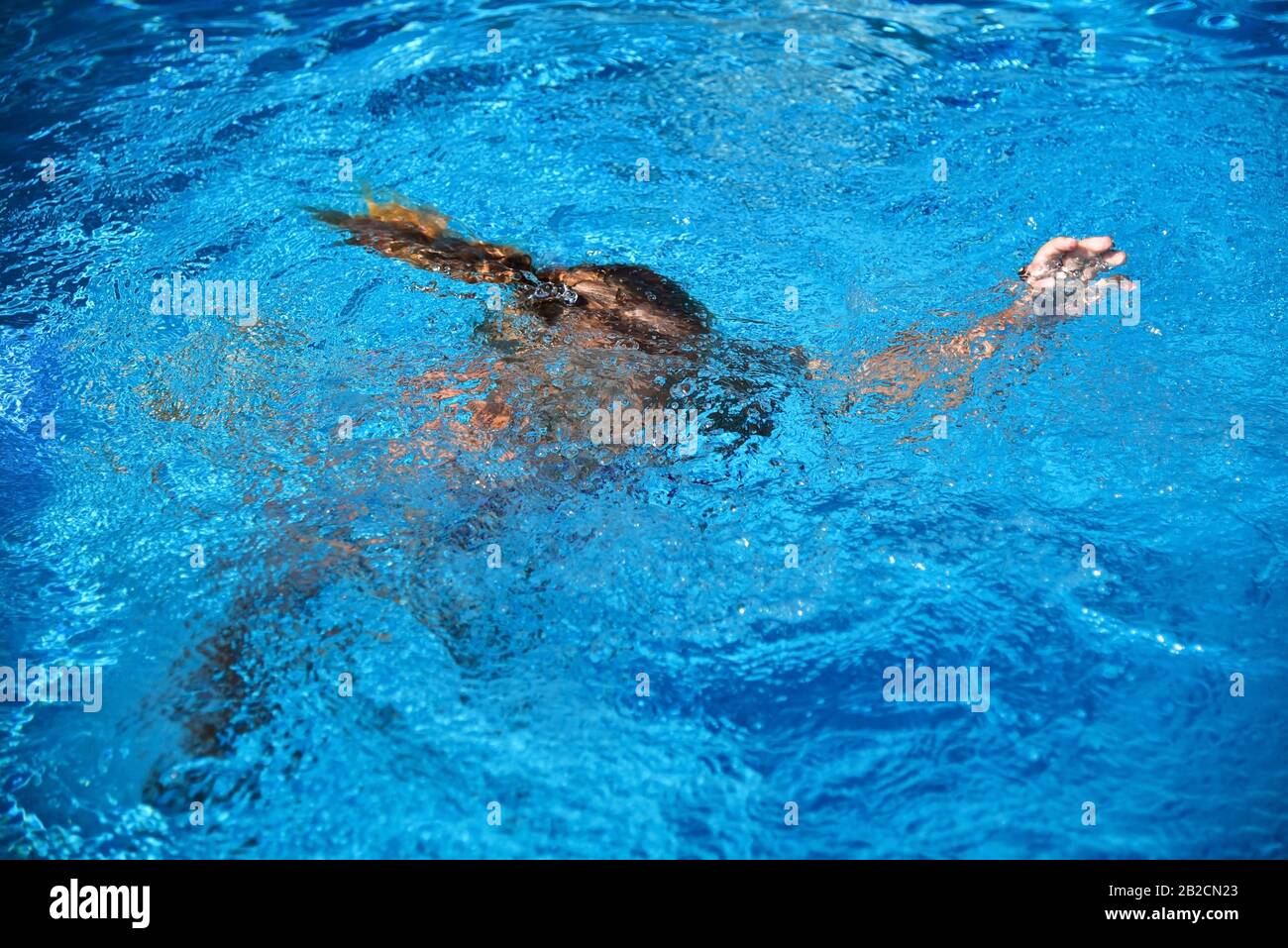 Little girl drowning in water while swimming in the pool or sea. Stock Photo