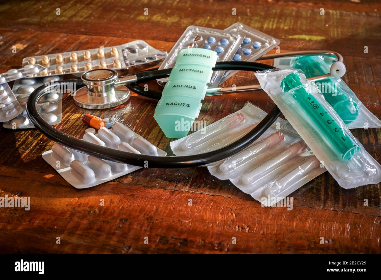 Various medical objects, such as stethoscopes and tablets, for the treatment and prevention of diseases. The text on the box is German for morning, no Stock Photo