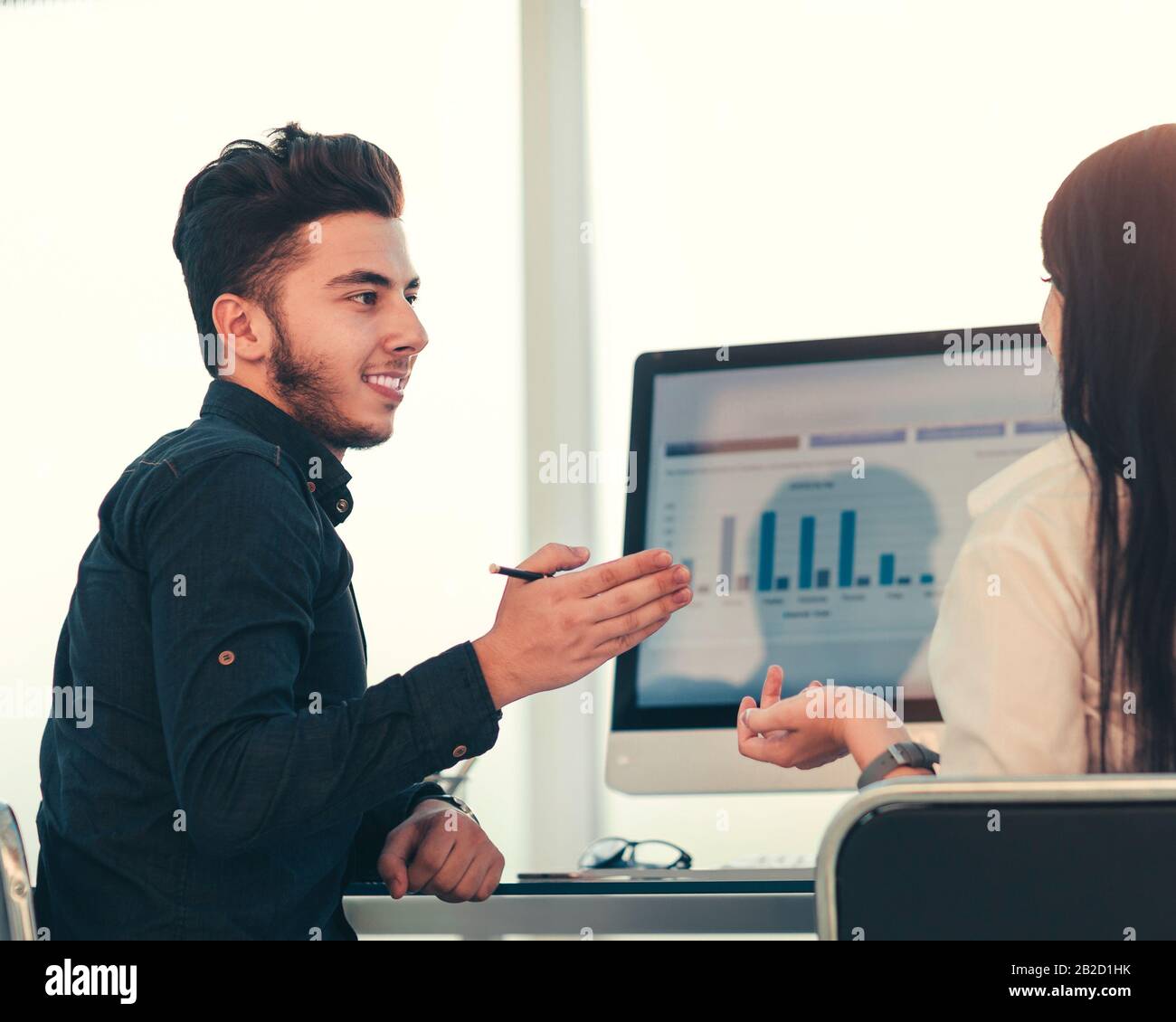 rear view. two employees discuss work issues sitting at the off Stock Photo