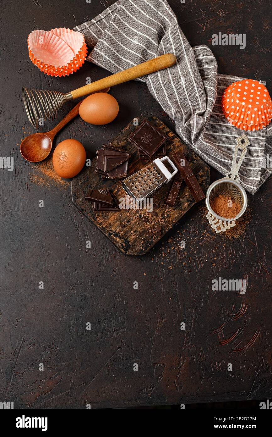 https://c8.alamy.com/comp/2B2D27M/chocolate-baking-ingredients-pieces-of-chocolate-chocolate-chips-cocoa-powder-and-eggs-on-a-wooden-cutting-board-on-a-dark-table-top-view-space-f-2B2D27M.jpg