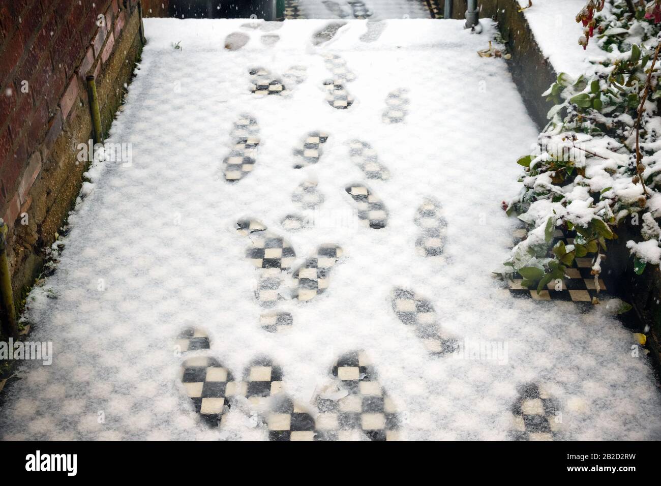 Footprints in white snow on doorstep in London Stock Photo