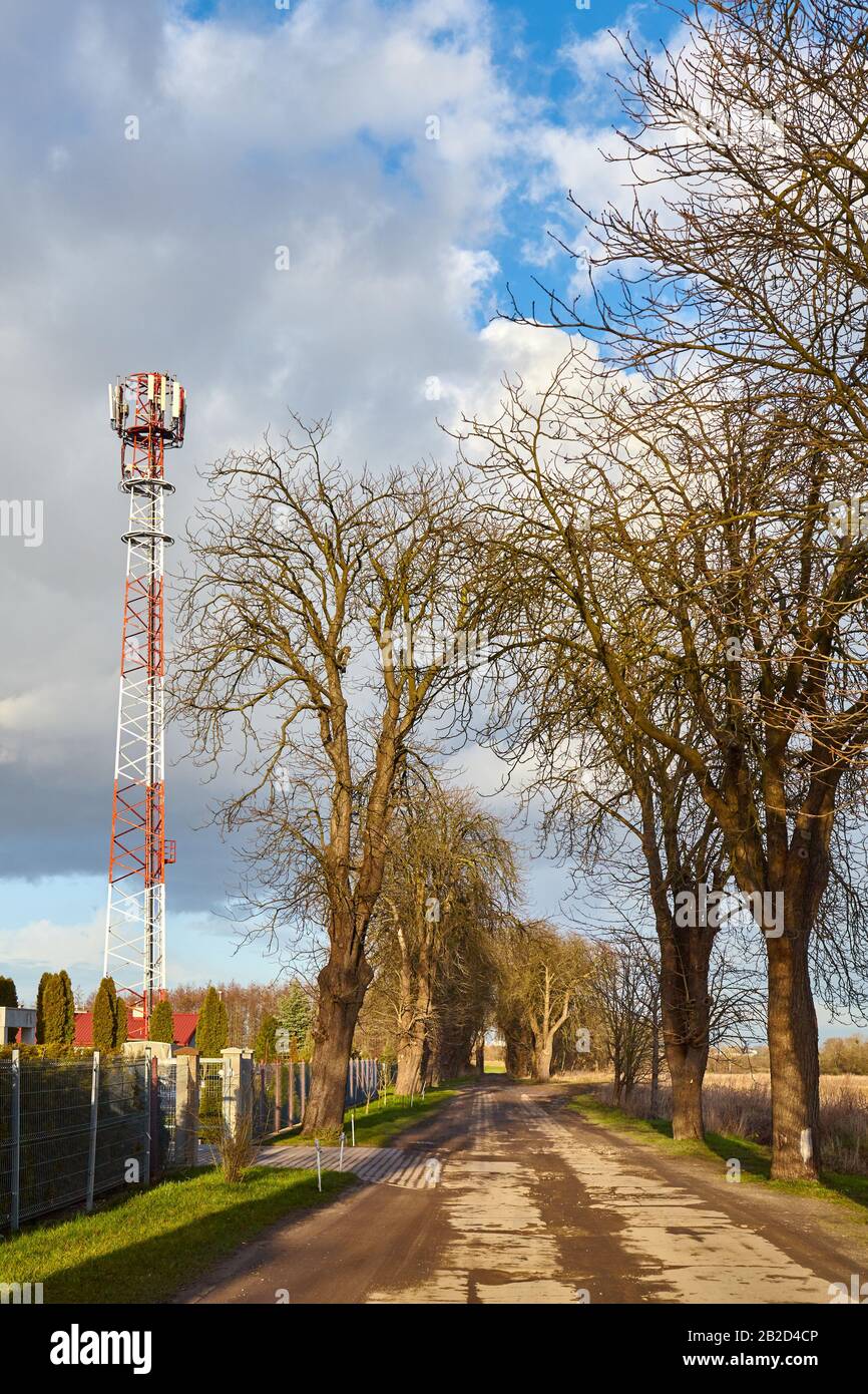Countryside road with telecommunication tower with antennas aside. Stock Photo