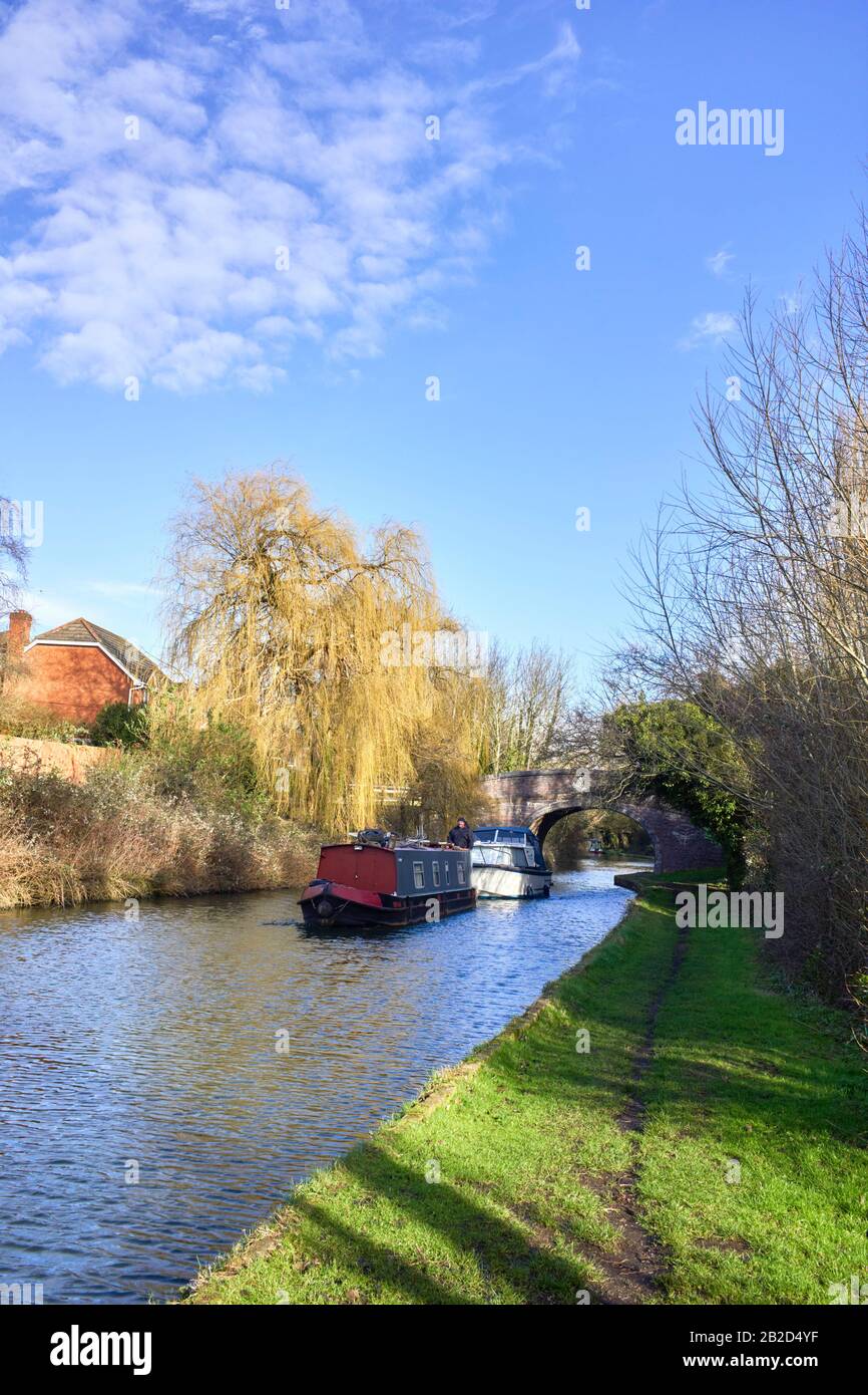 A narrowboat towing another boat at Milton Keynes in winter on the Grand Union Canal Stock Photo