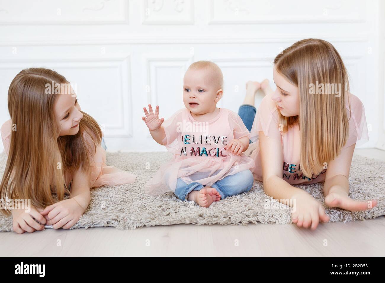 Light family series. Three sisters on a white background, dressed in funny t-shirts and jeans Stock Photo - Alamy Light family series. Three sisters on a white background, dressed in funny t-shirts and jeans Stock Photo - Alamy