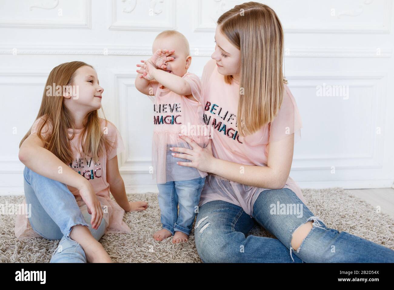 Light family series. Three sisters on a white background, dressed in funny t-shirts and jeans Stock Photo - Alamy Light family series. Three sisters on a white background, dressed in funny t-shirts and jeans Stock Photo - Alamy
