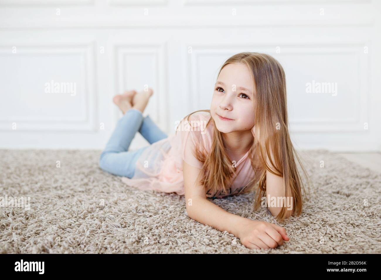 Cute pre-teen girl wearing fashion clothes posing in white interior. little  but very serious girl Stock Photo - Alamy
